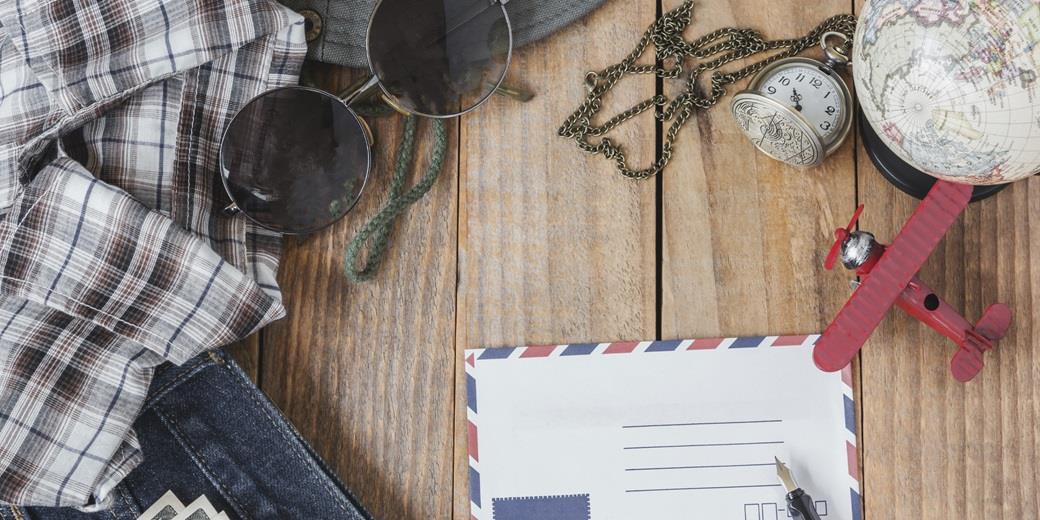 A globe, a letter, sunglasses and a small plain