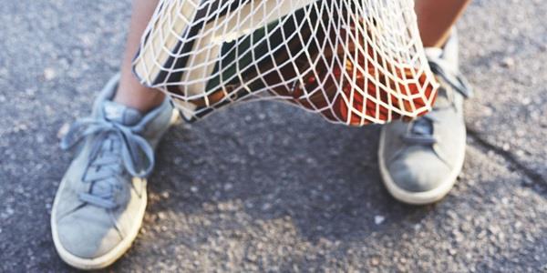 Bare legs, sneakers, summer and a bag of books