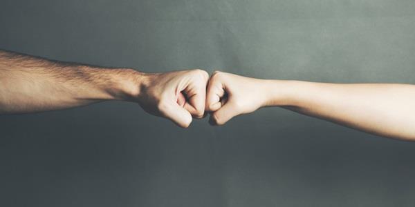 Two hands giving respect with a fist bump