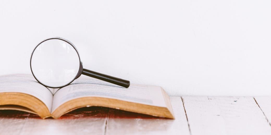 Magnifying glass for investigating on top of a book