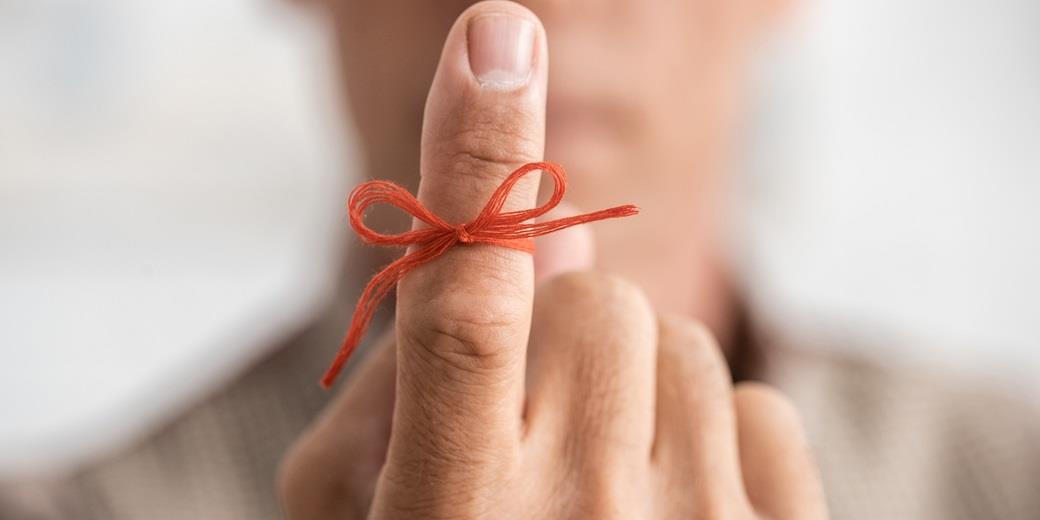 A red thread in a bow on a finger